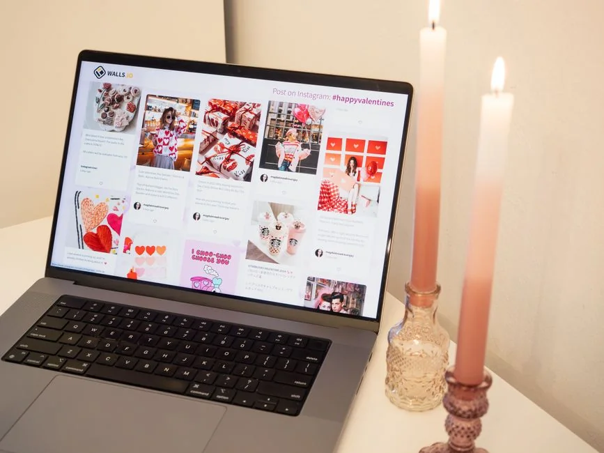 A laptop on a bed showing web design software, creating a cozy workspace.